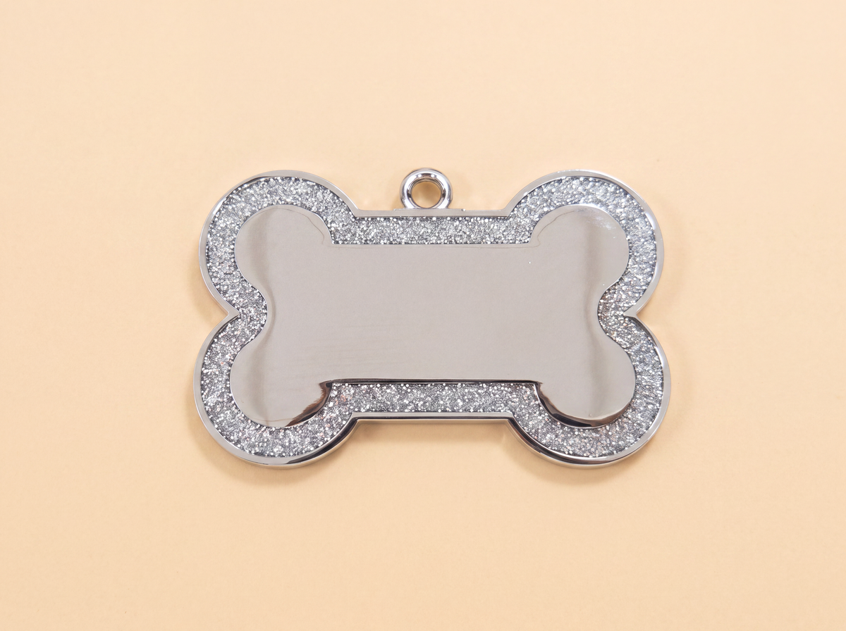 Botvormige hondenpenning met glitterrand en blanco midden, zilver