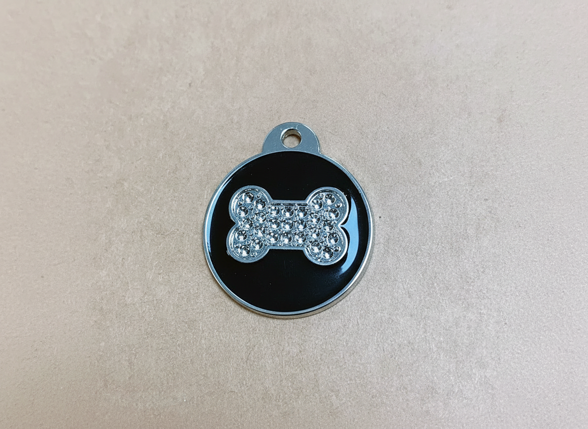 Ronde hondenpenning met botmotief en strass-steentjes, zwart